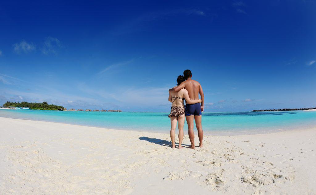 happy young asian couple enjoying summer and have on beautiful white sand beach