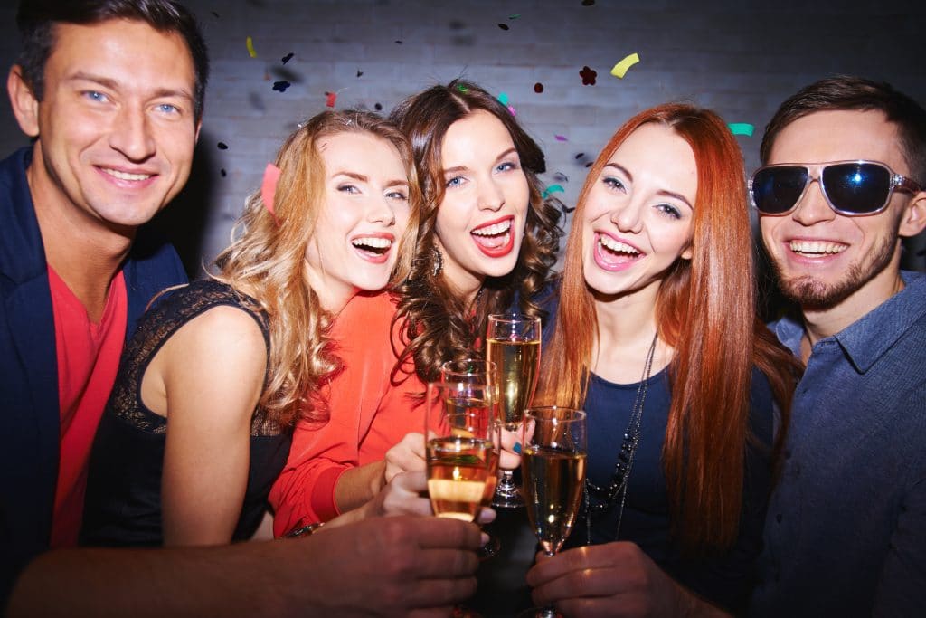 Ecstatic friends with champagne having party