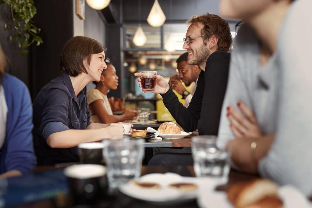 Fabrique Love- Busy cafe with a young couple smiling at each other