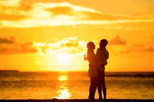 Man Hugging His Wife On The Beach During a Lovely Sunset a good advice on dating