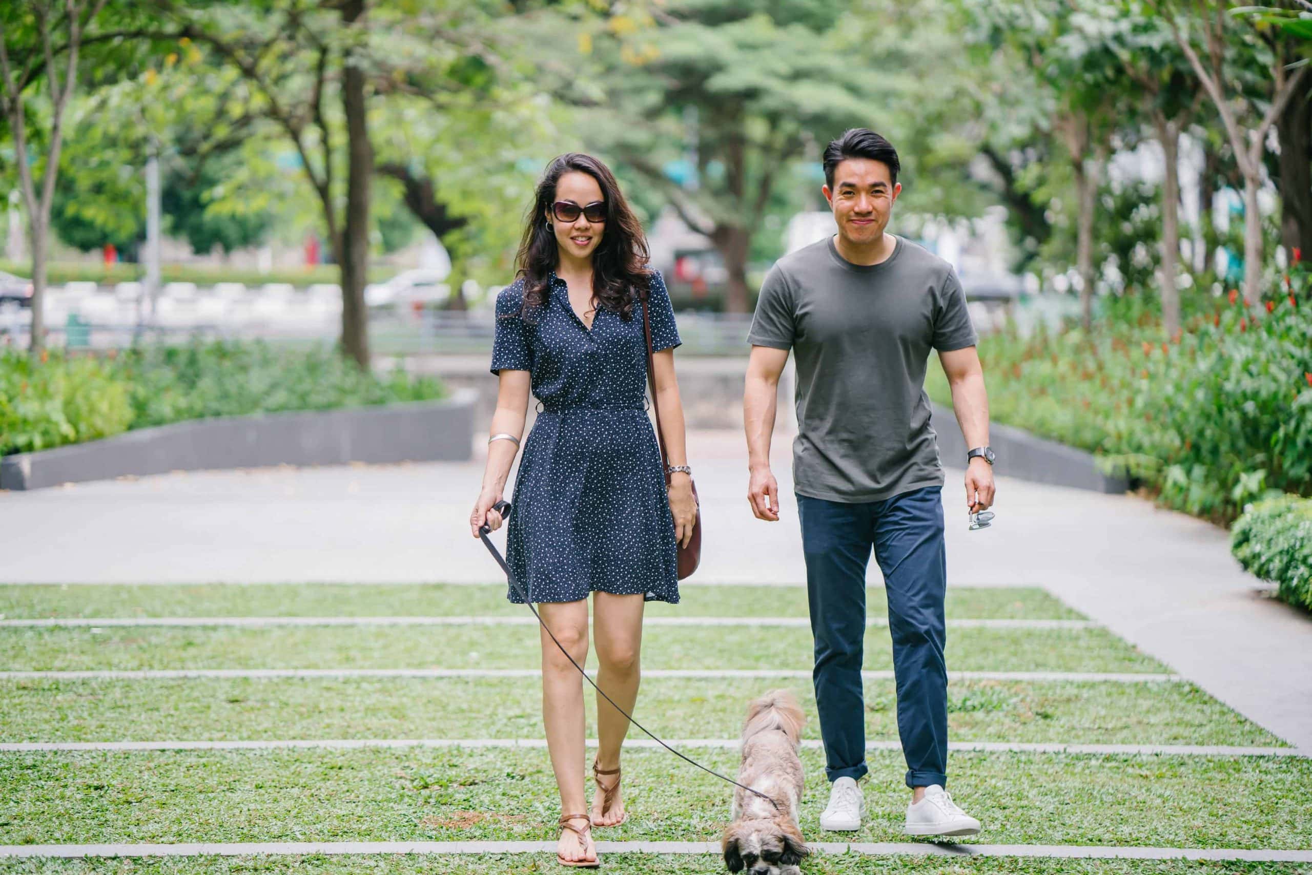Asian couple on a date walking their pet dog