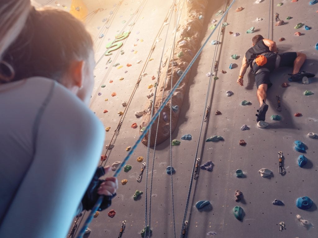 Support concept. Mutual agreement. Climbering in boulder gym. Climbing on wall.