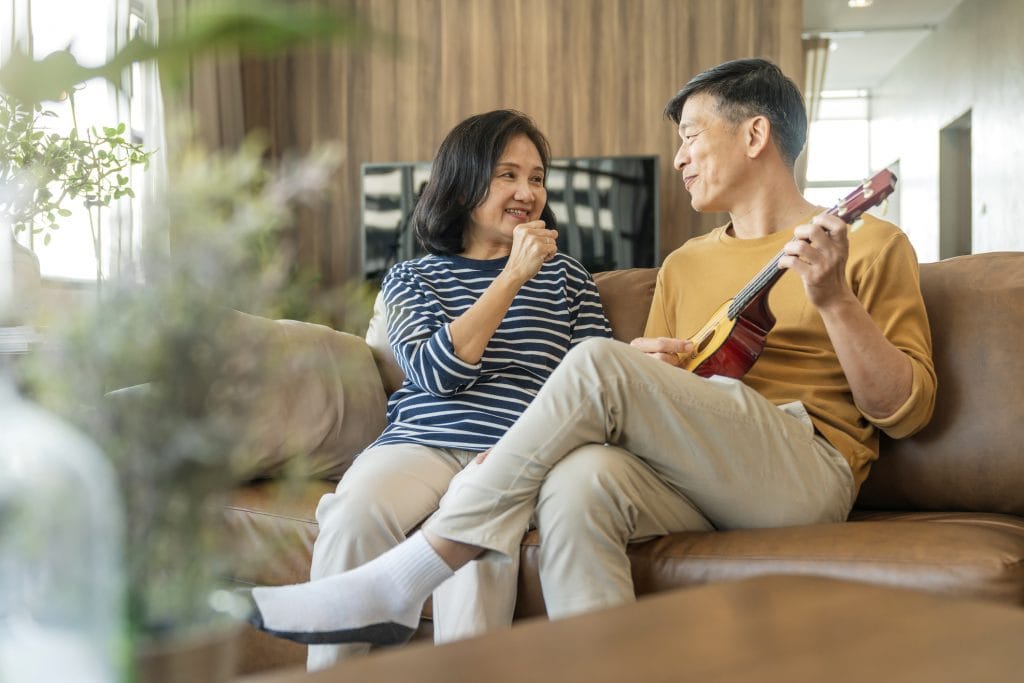 sweet Asian senior Couple sing play acoustic ukulele instrument. Happy Smiling Elderly grandparent having fun and enjoying their Retirement life. Lifestyle, Party happy lifestyle