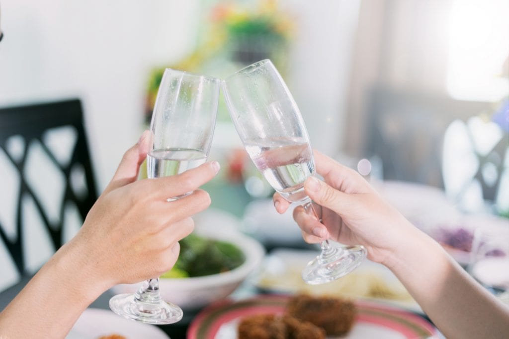 Asian young couple enjoying a romantic dinner  evening drinks while sitting at the dinning table on the kitchen together