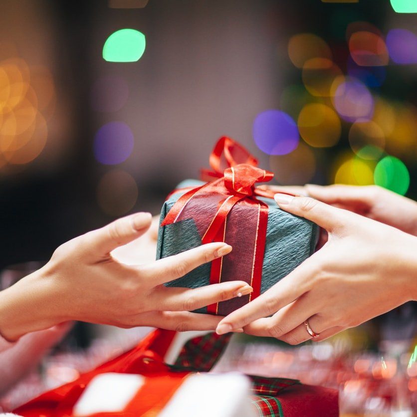 Close-up photography of two hands while giving gift.